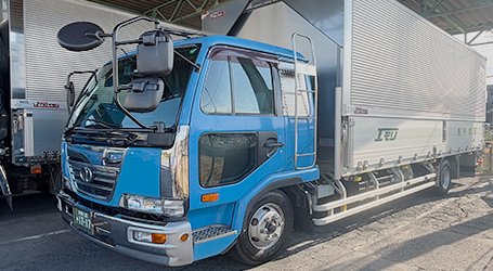 小型トラックが工場の前に停車している写真